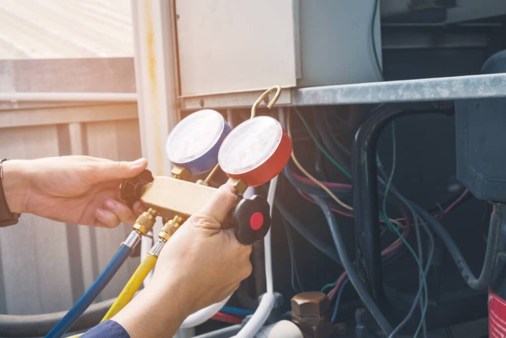 HVAC technician using pressure gauge